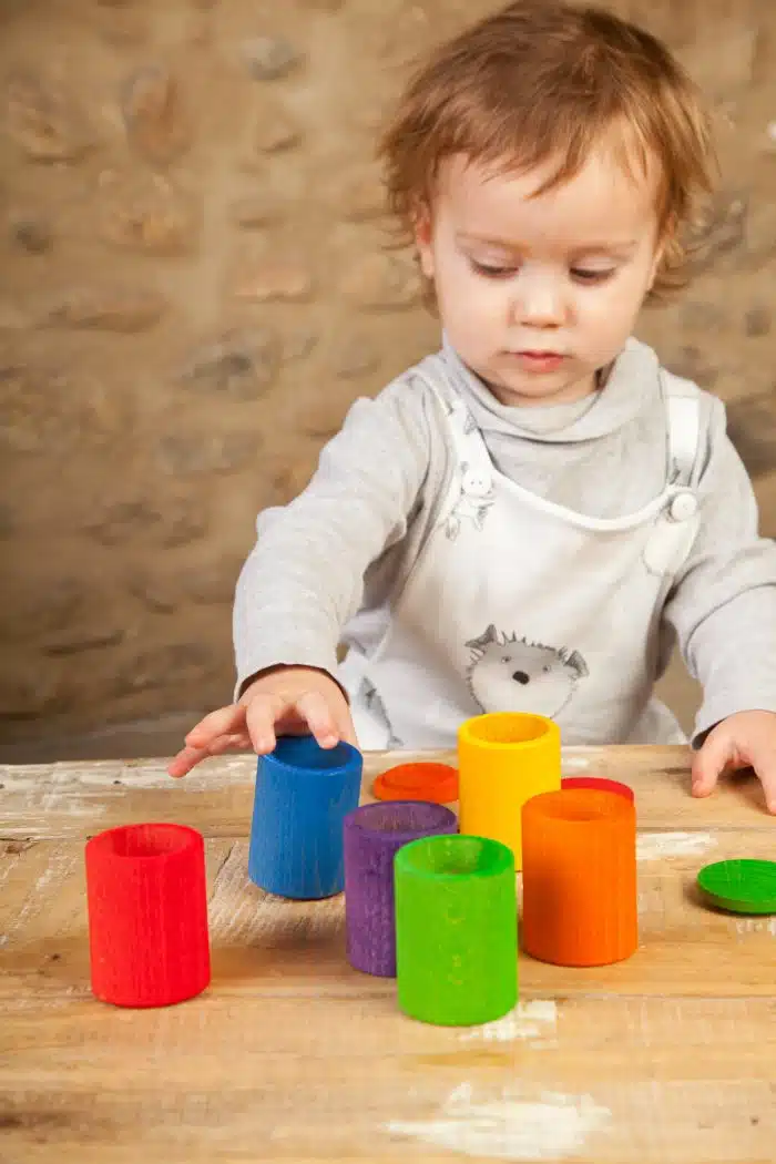 Kind speelt met houten Regenbook bakjes