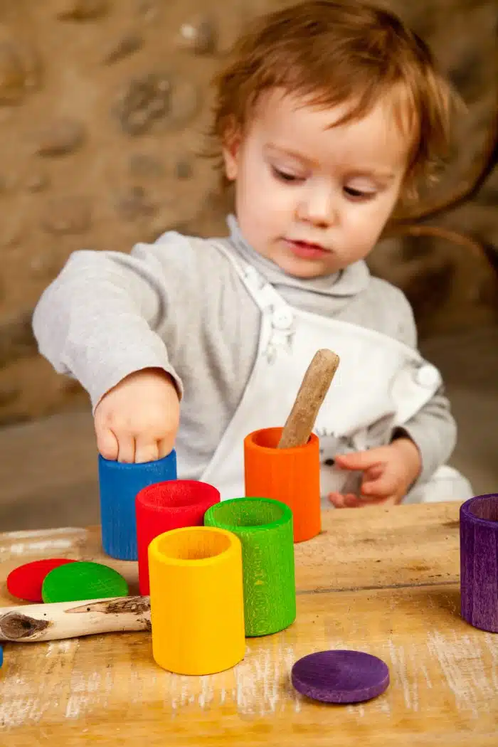 Kind speelt met houten Regenbook bakjes