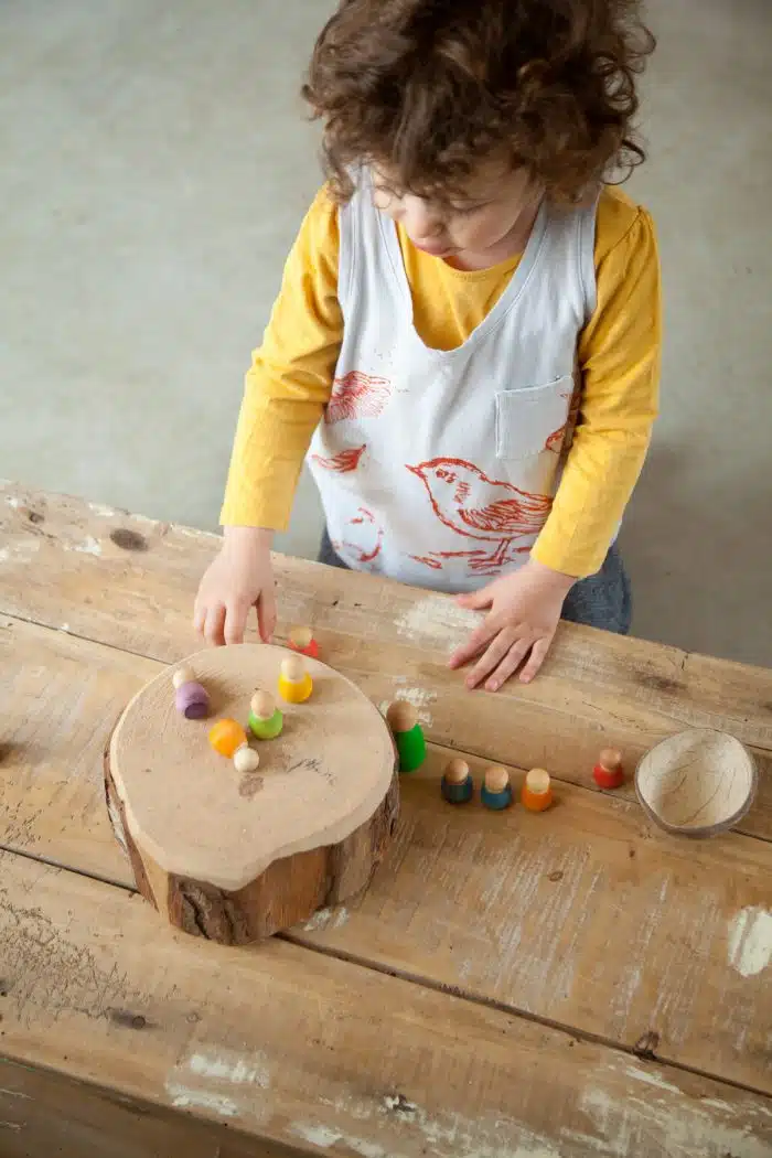 Kind speelt met Grapat Houten Baby Nins Poppetjes