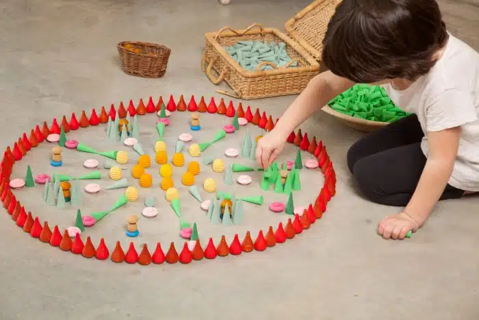 Kind maakt een cirkel van Grapat Mandala Houten Kegels