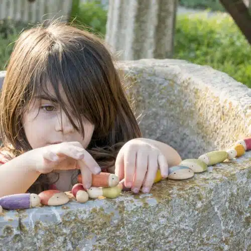 Kind speelt met Houten Regenboog Insecten – Lieveheersbeestjes, Mieren en Naaktslakken