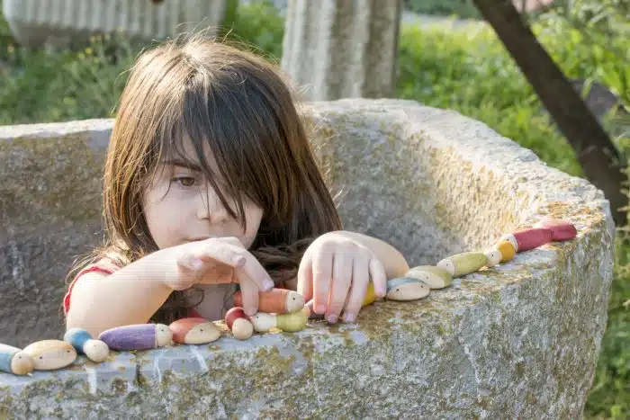 Kind speelt met Houten Regenboog Insecten – Lieveheersbeestjes, Mieren en Naaktslakken