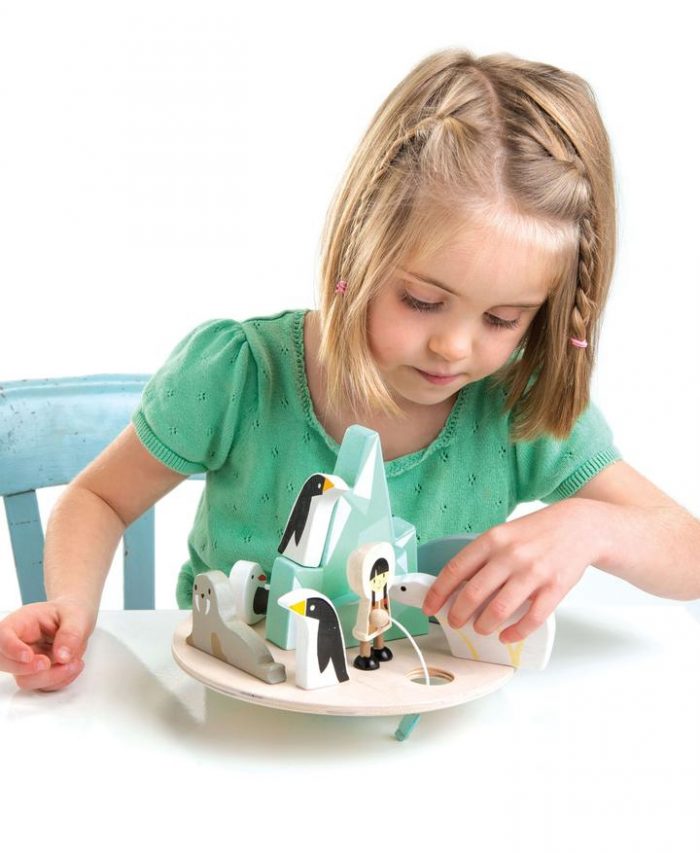 girl playing with a wooden balancing arctic circle game