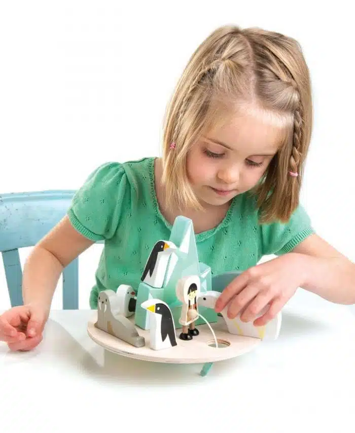 girl playing with a wooden balancing arctic circle game